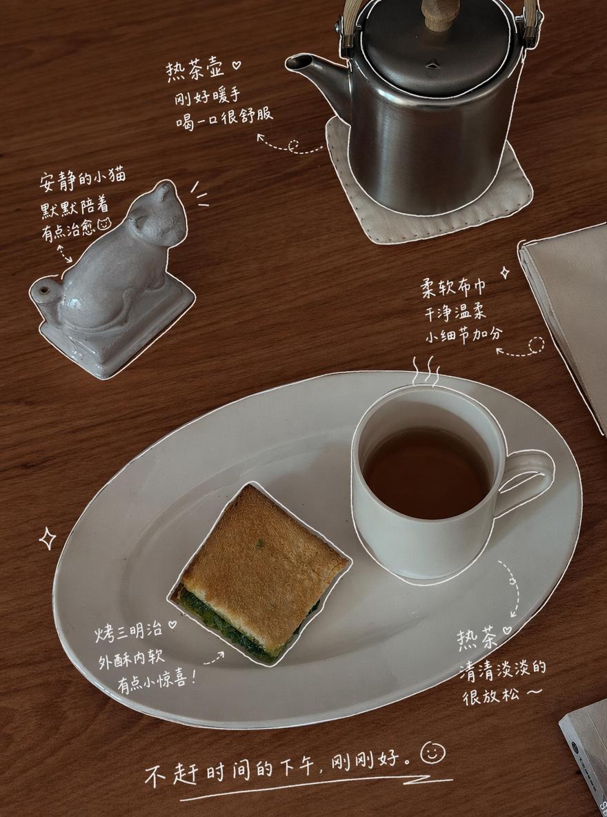 A Cozy Table Setting Featuring A Cup Of Tea A Small Ceramic Cat Figure And A Toasted Sandwich Perfect For A Quiet Afternoon Break