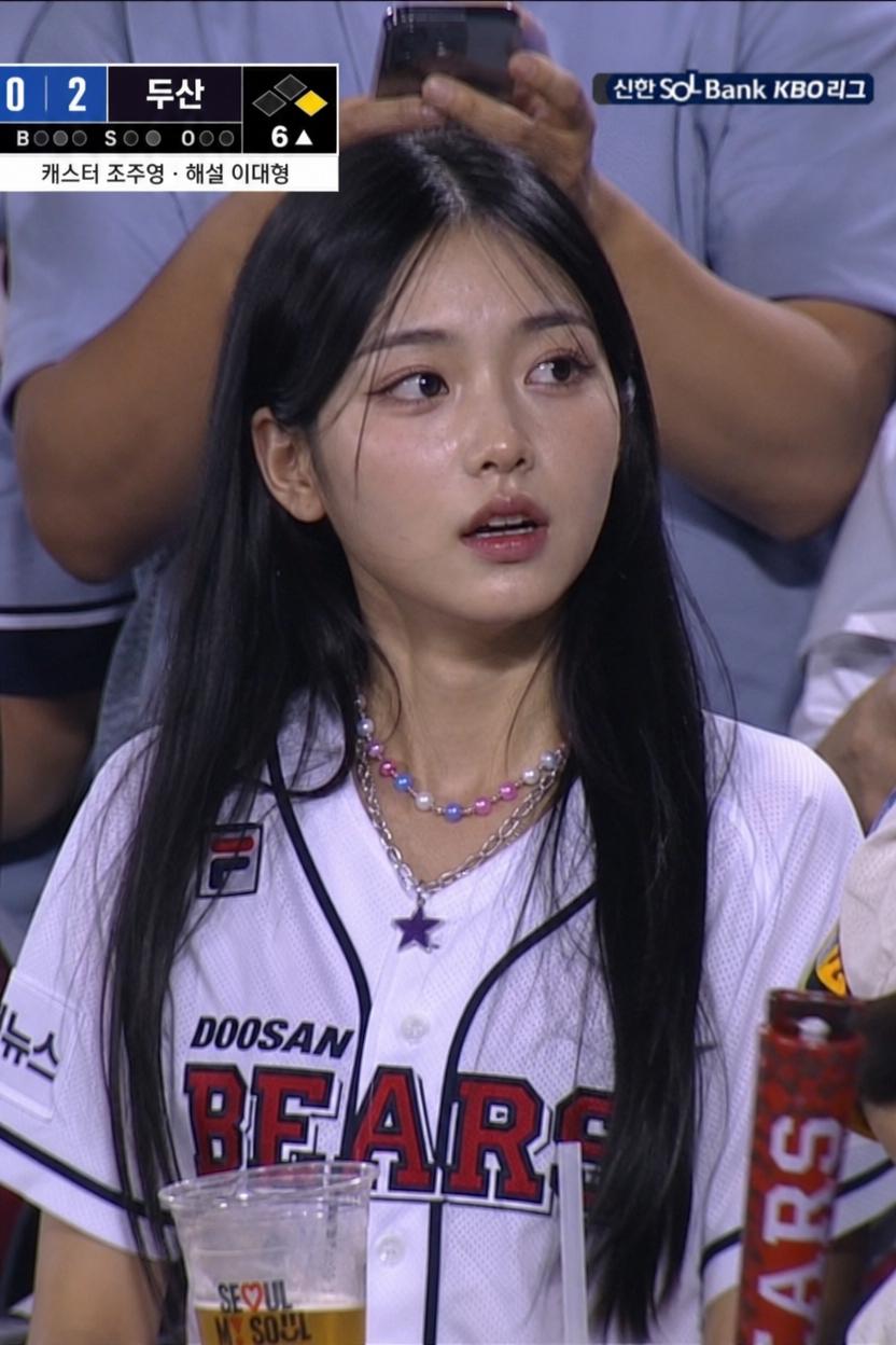 A Woman Wearing A Doosan Bears Jersey Is Watching A Baseball Game In A Crowded Stadium Setting
