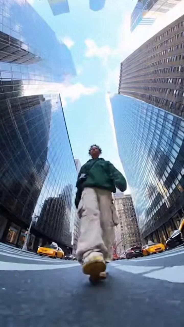 The video shows a young woman filmed from an extreme low-angle, wide-angle perspective on 